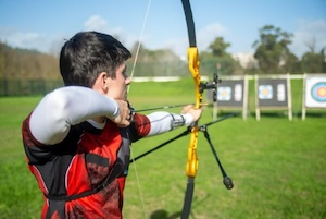 man at archery range aiming at target